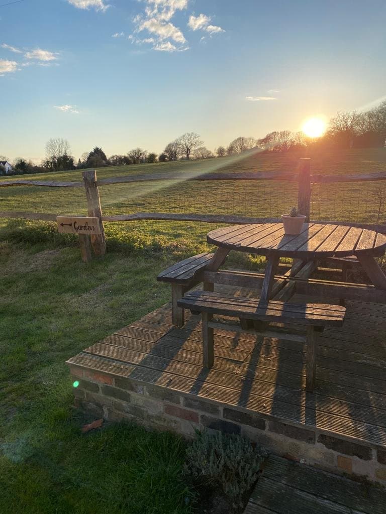Beer garden picnic table looking out over open fields at sunset